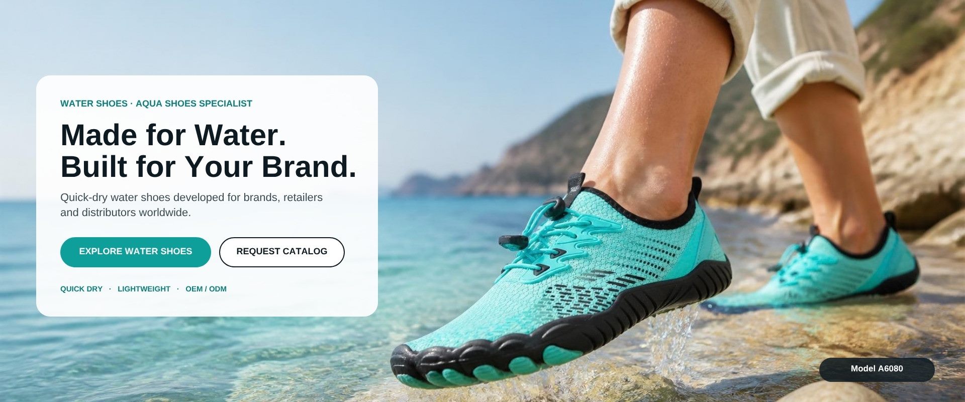 Model A6080 aqua barefoot water shoe stepping through shallow sea water on a rocky shore